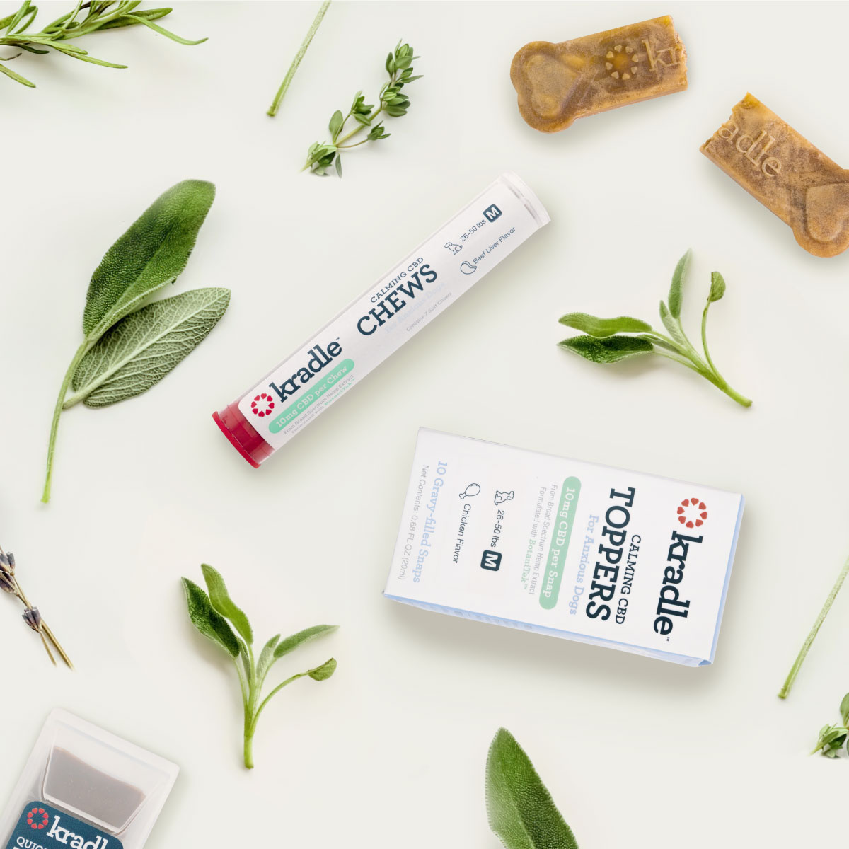 Kradle Calming CBD Chews and Calming CBD Toppers laying on a table with plants.