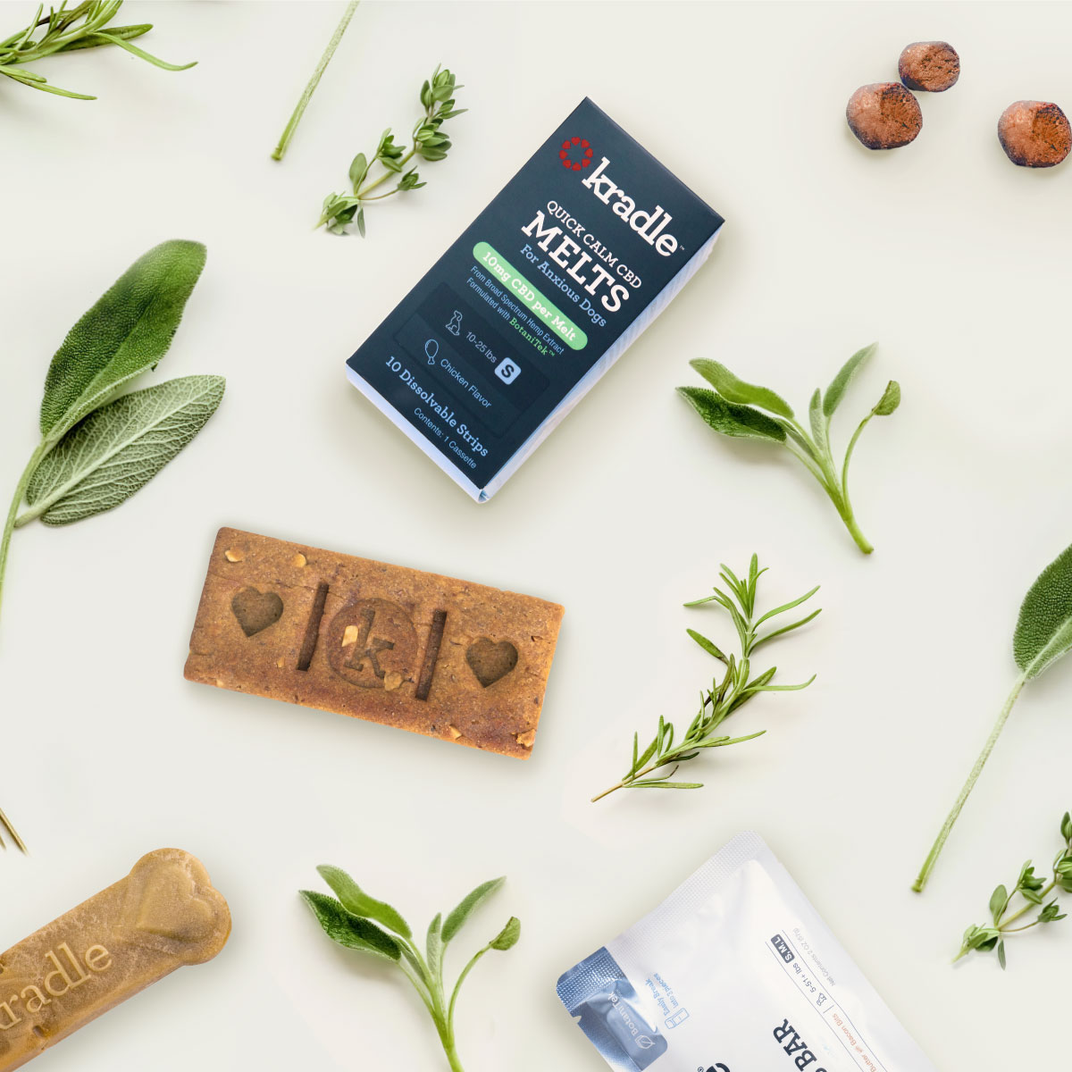 Kradle Quick Calm CBD Melts and Calming Bliss Bar laying on a table with plants.