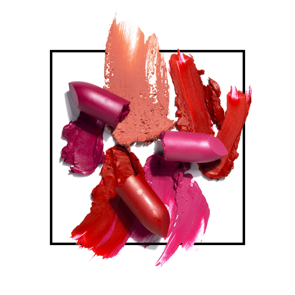 A small group of pieces of red, purple, and pink lipstick products, both in tact and smeared around.