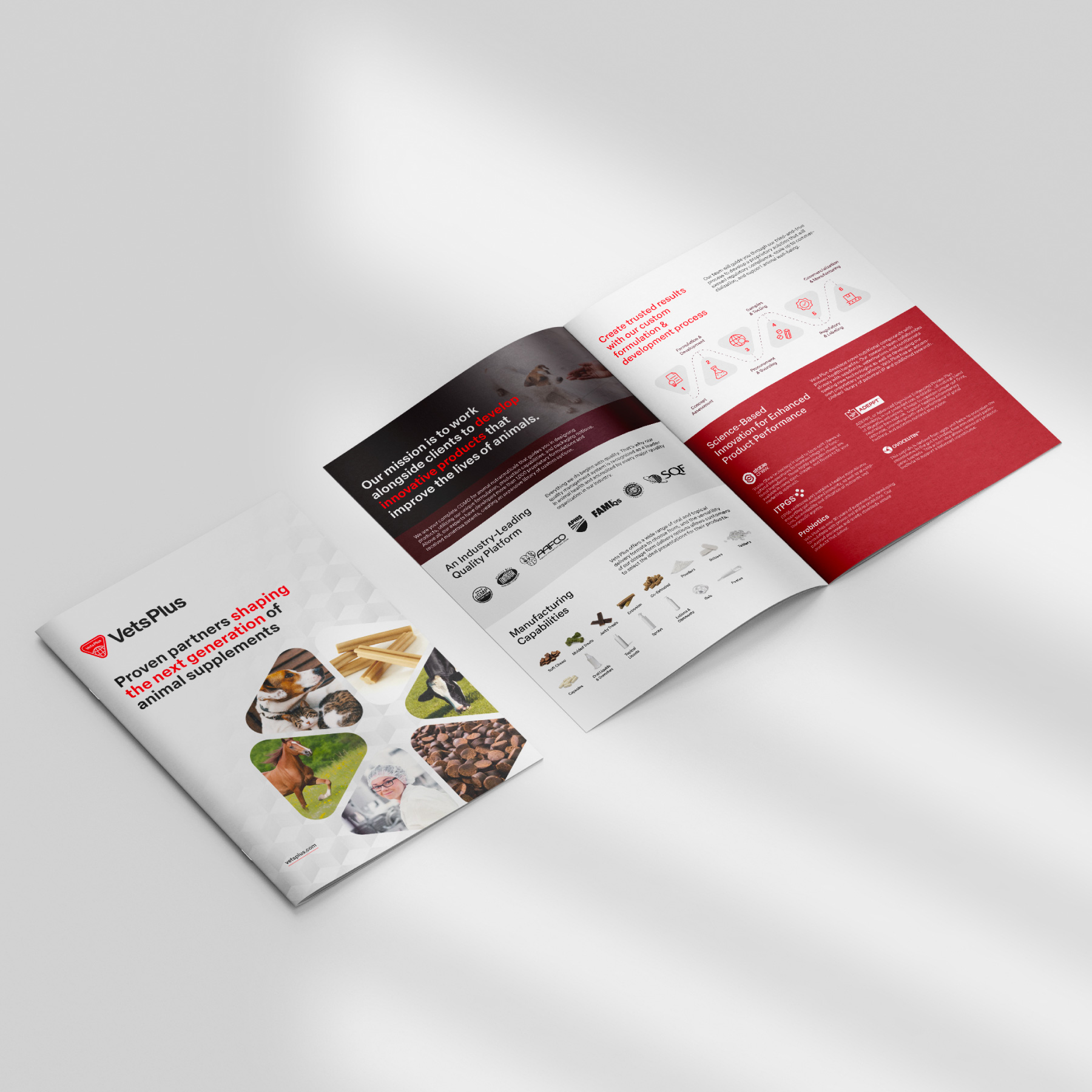 Two corporate brochures laid out on a table. The brochure on the left is closed and the front is facing up. The brochure on the right is open to show two inner-pages. The front of the brochure reads "Proven partners shaping the next generation of animal supplements". Above that is the Vets Plus logo and below is a wheel of images showing a horse, a dog and cat laying together, a pile of animal chew treats, a cow grazing, a pile of animal supplement chews, and a woman wearing a hairnet, glasses and a lab coat looking over her shoulder into the camera. The inside of the brochure contains obscured text, images, and icons in color-blocked sections of maroon, grey, white, and red.